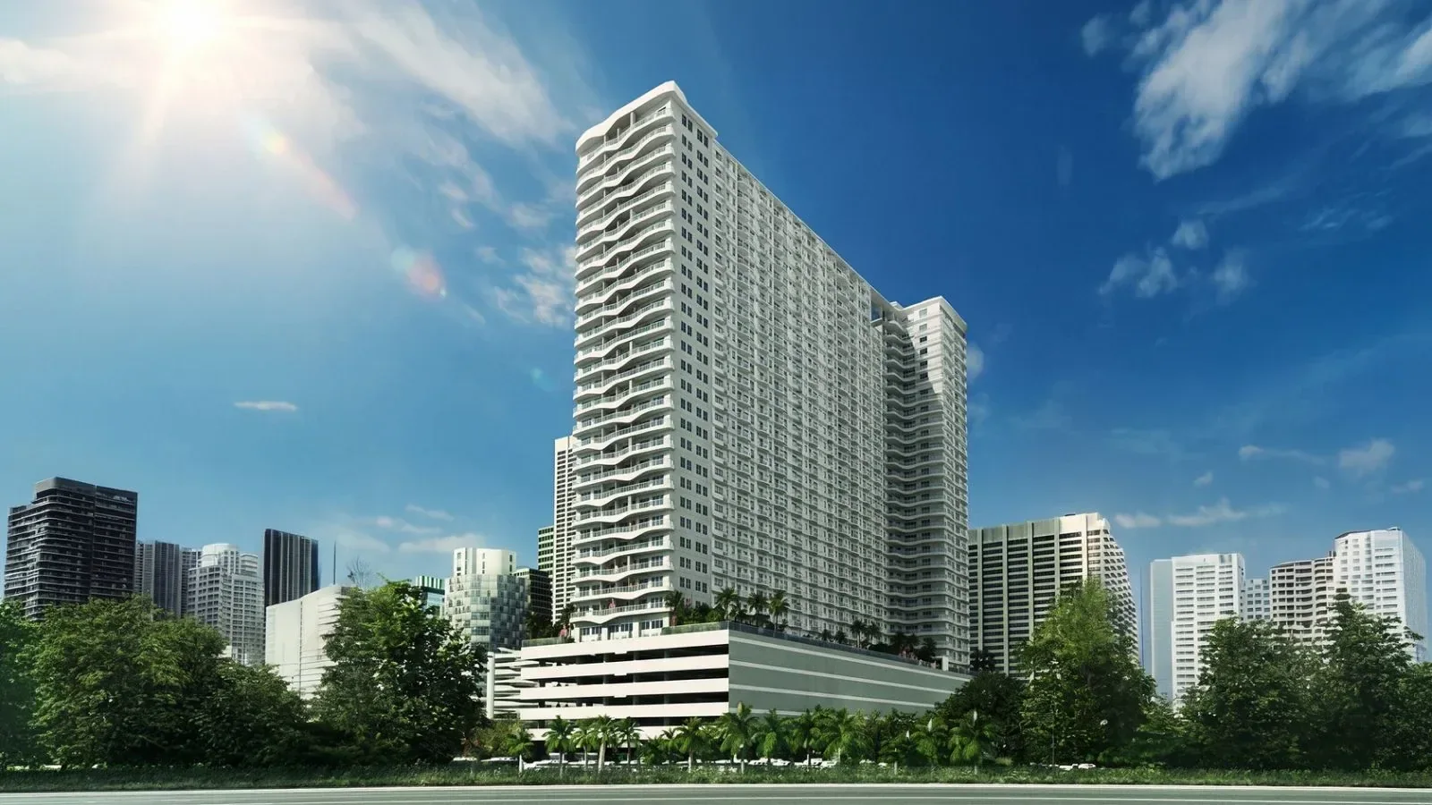 The Coast Residences tower on Roxas Boulevard, its curved balconies stepping up the facade against the Manila skyline.